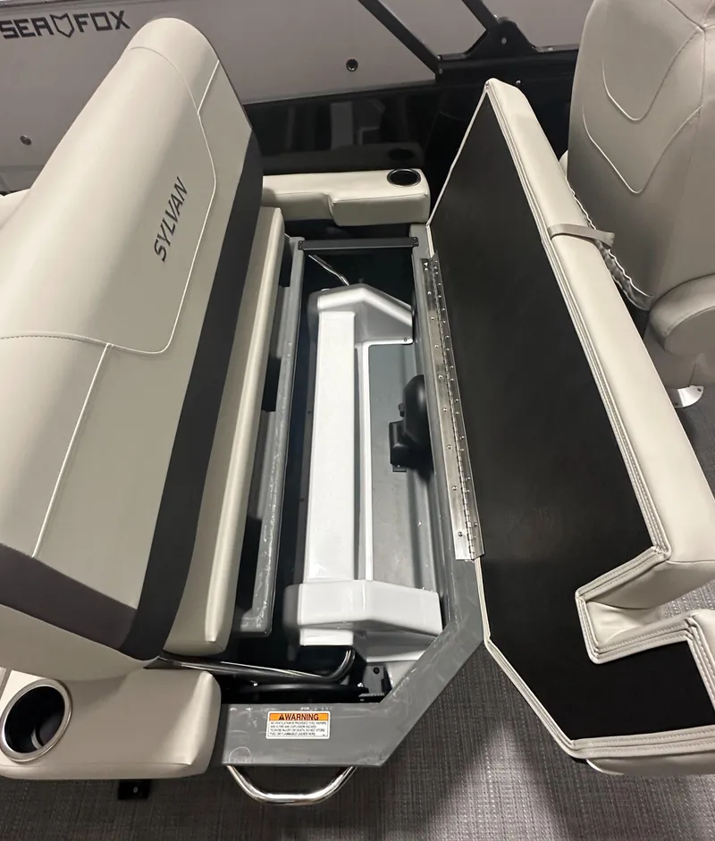 Slide: The Image of 2025 Sylvan Mirage X3 CLZ DH boat interior storage compartment with beige seating. - 9