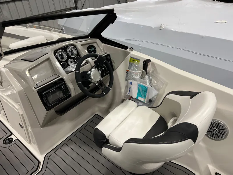 Slide: The Image of 2024 Starcraft SVX 210 OB boat cockpit with steering wheel and captain's chair. - 8