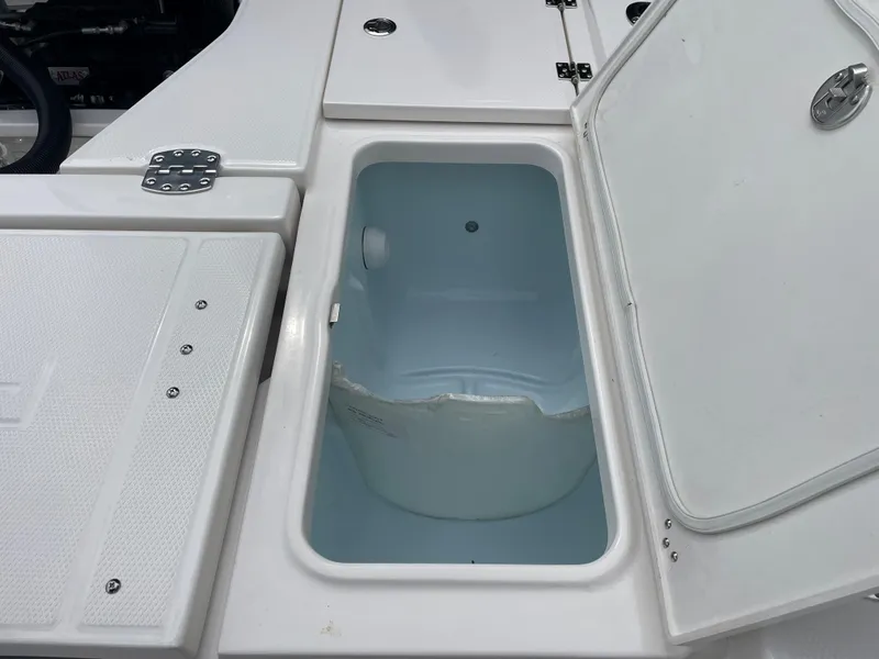 Slide: The Image of 2023 Robalo 266 Cayman boat storage compartment with open lid. - 10