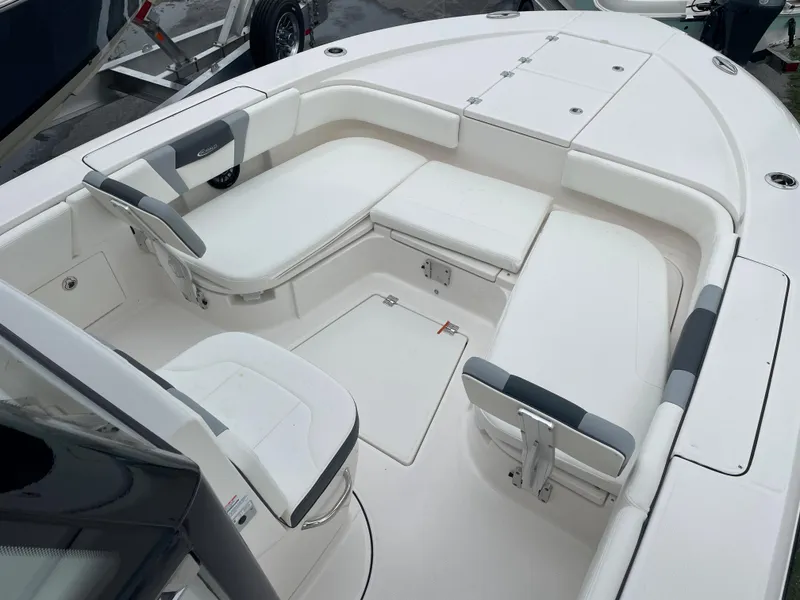 Slide: The Image of 2023 Robalo 266 Cayman boat interior with white cushioned seating and storage compartments. - 14