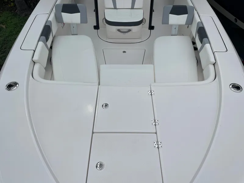 Slide: The Image of 2023 Robalo 266 Cayman boat interior with white cushioned seating and storage compartments. - 17
