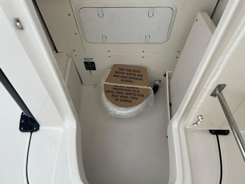 Slide: The Image of 2023 Robalo 266 Cayman boat interior with a covered toilet and storage compartment. - 20