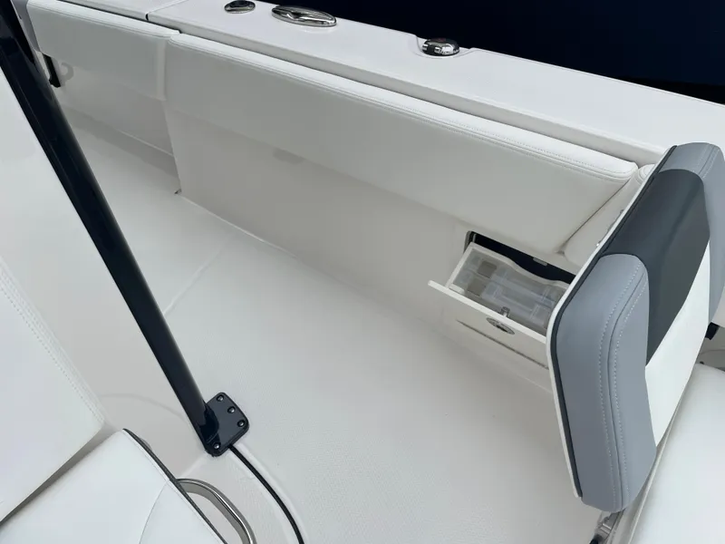 Slide: The Image of 2023 Robalo 266 Cayman boat interior with white seating and storage compartment. - 24