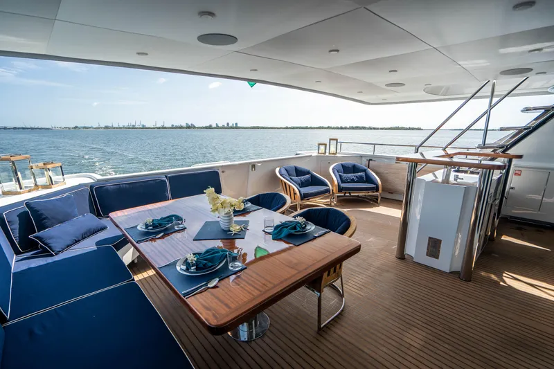 Slide: The Image of Luxurious deck of 1989 Broward Tri-Deck yacht with dining area and ocean view. - 2
