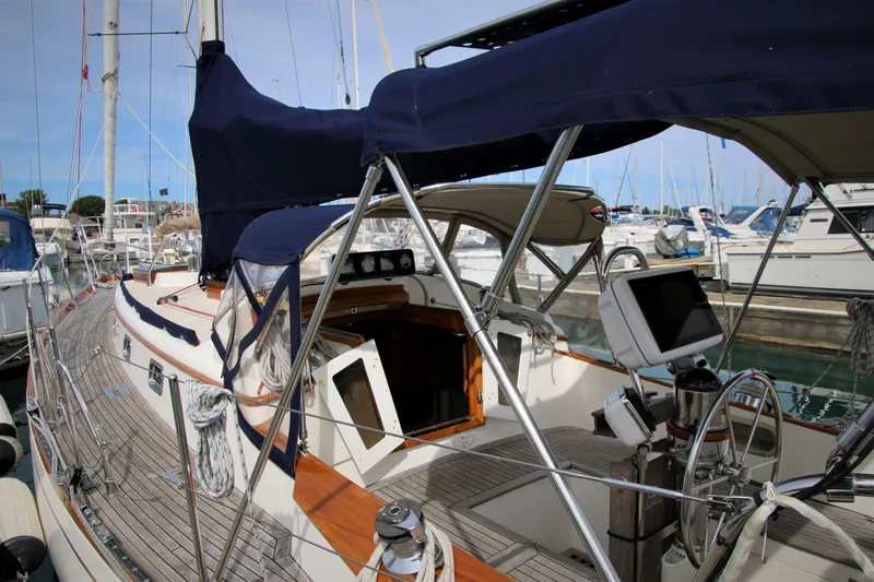 Slide: The Image of 1986 Mason 33 sailboat with blue canopy docked at marina. - 18
