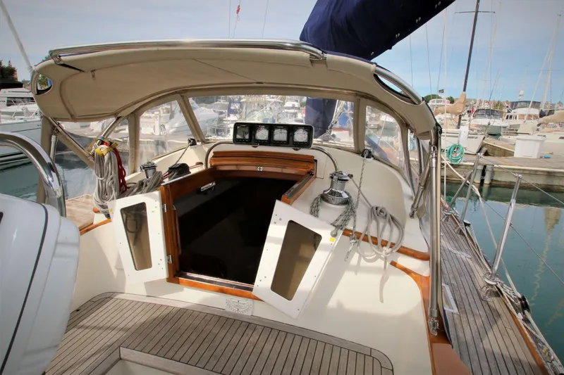 Slide: The Image of 1986 Mason 33 sailboat cockpit with wooden accents, docked at a marina. - 19