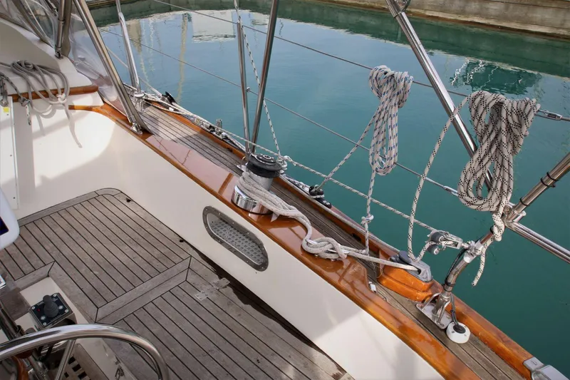 Slide: The Image of Sailboat deck with ropes and winch, Mason 33, 1986 model, docked by calm water. - 25