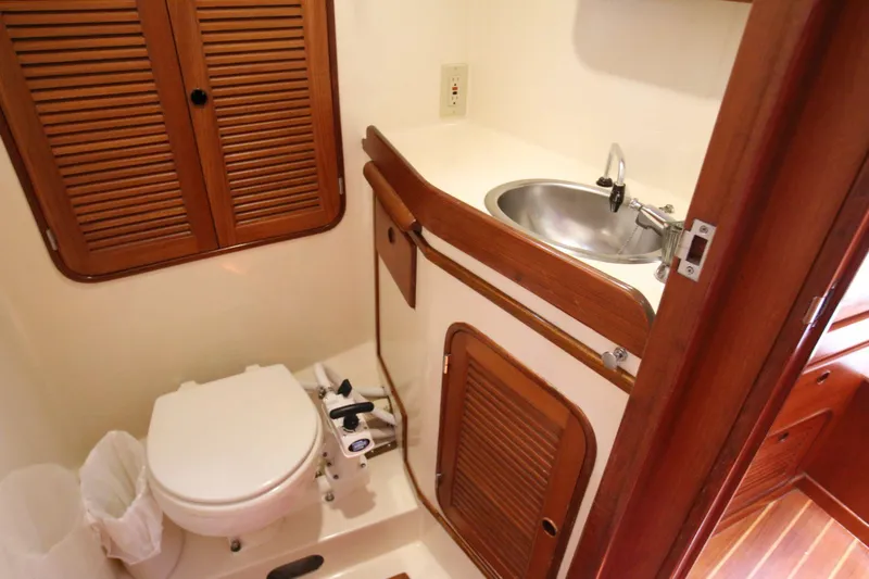 Slide: The Image of Compact bathroom in 1986 Mason 33 yacht with toilet, sink, and wooden cabinetry. - 26