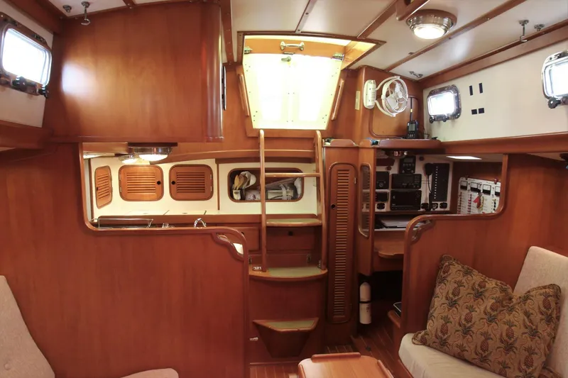 Slide: The Image of 1986 Mason 33 yacht interior with wooden finish, cozy seating, and navigation equipment. - 31
