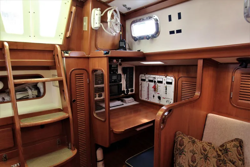 Slide: The Image of Interior of a 1986 Mason 33 sailboat with wooden cabinetry and navigation station. - 33