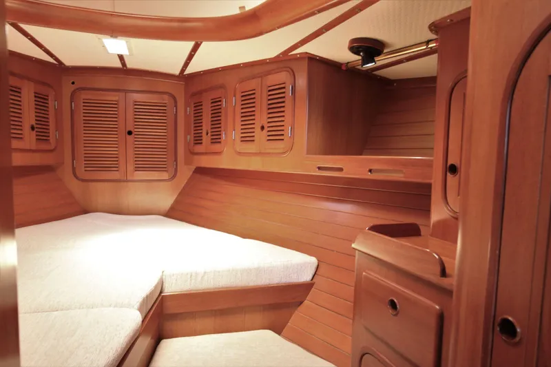 Slide: The Image of 1986 Mason 33 yacht interior with wooden cabinetry and cozy sleeping area. - 35