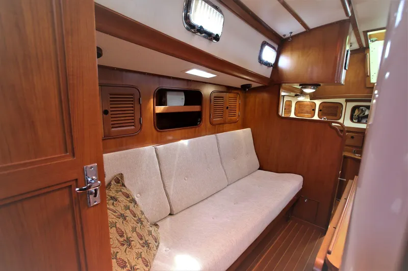 Slide: The Image of Cozy interior of 1986 Mason 33 sailboat with wooden paneling and cushioned seating. - 39