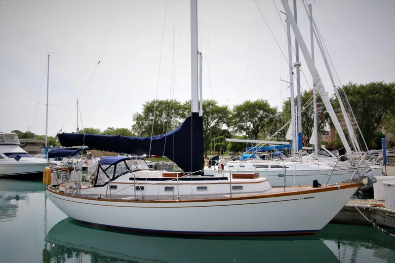 Slide: The Image of Sailboat Mason 33, 1986 model, docked in a marina with other boats. - 4
