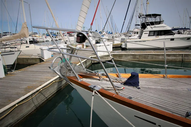 Slide: The Image of 1986 Mason 33 sailboat docked in a marina, surrounded by other boats. - 7