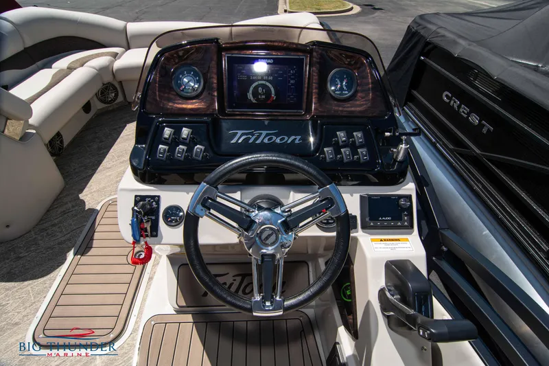 Slide: The Image of 2022 JC SunLounger 25 TT Sport boat dashboard with steering wheel and control panel. - 19