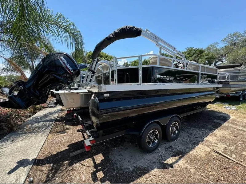 The Image of 2024 Ranger Reata 200C pontoon boat on trailer, parked outdoors. - 0