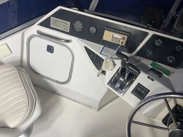 Slide: The Image of 1989 Sea Ray 300 Sedan Bridge helm with controls and instrumentation. - 10