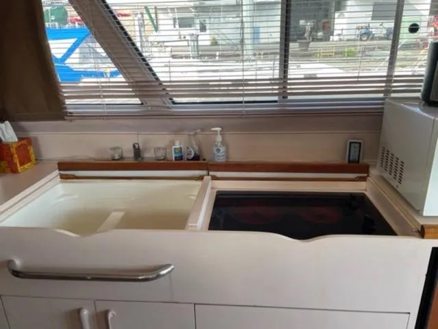 Slide: The Image of 1989 Sea Ray 300 Sedan Bridge kitchen with sink, stove, and microwave. - 19