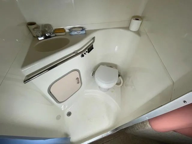 Slide: The Image of Compact bathroom in 1989 Sea Ray 300 Sedan Bridge boat with toilet and sink. - 20