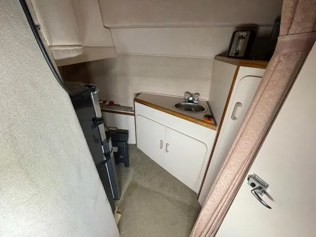 Slide: The Image of Compact kitchen area in a 1989 Sea Ray 300 Sedan Bridge boat. - 21
