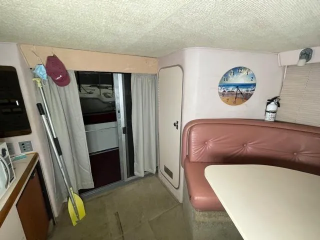 Slide: The Image of Interior of 1989 Sea Ray 300 Sedan Bridge with dining area and sliding door. - 22