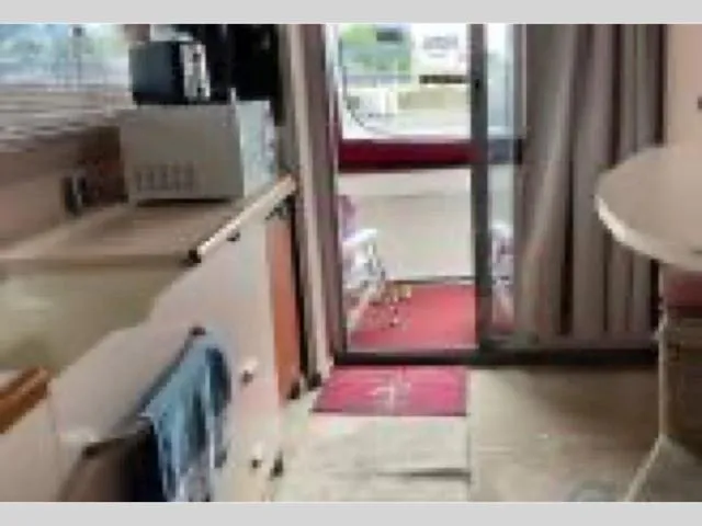 Slide: The Image of Interior of 1989 Sea Ray 300 Sedan Bridge with kitchenette and sliding door. - 29