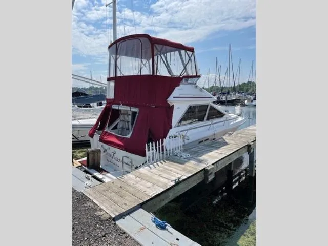 Slide: The Image of 1989 Sea Ray 300 Sedan Bridge docked at a marina with red canvas cover. - 4