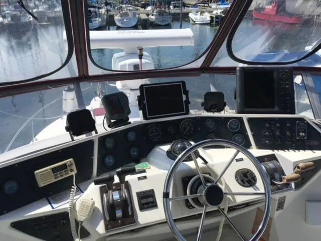 Slide: The Image of 1989 Sea Ray 300 Sedan Bridge helm with navigation instruments and marina view. - 7