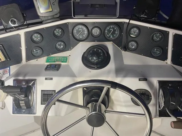 Slide: The Image of 1989 Sea Ray 300 Sedan Bridge helm with gauges and steering wheel. - 8