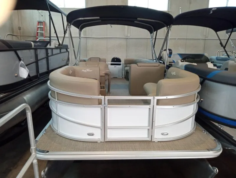 The Image of 2023 SunChaser Vista 20 LR pontoon boat with beige seating in showroom. - 0