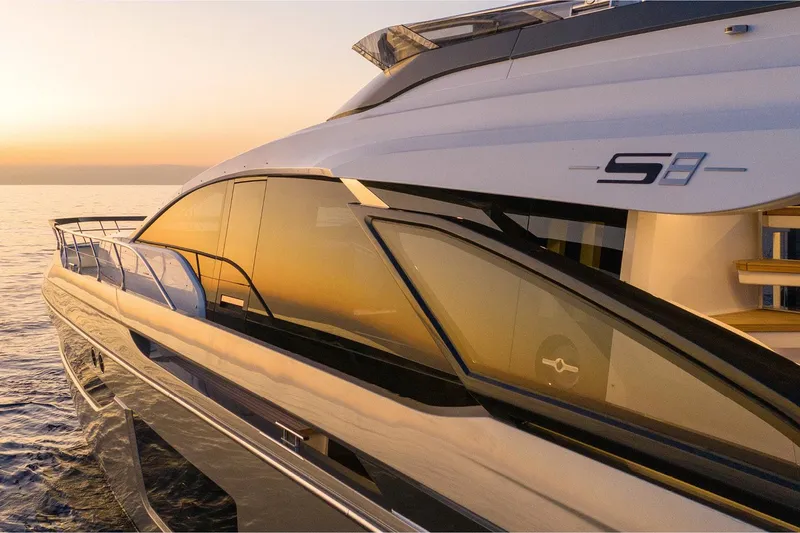 Slide: The Image of 2022 Azimut S8 yacht at sunset, sleek design reflecting golden hues on the water. - 7