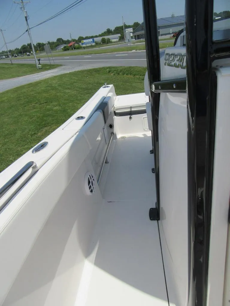 Slide: The Image of 2023 Robalo R230 Center Console boat interior, side view with clean white deck. - 10