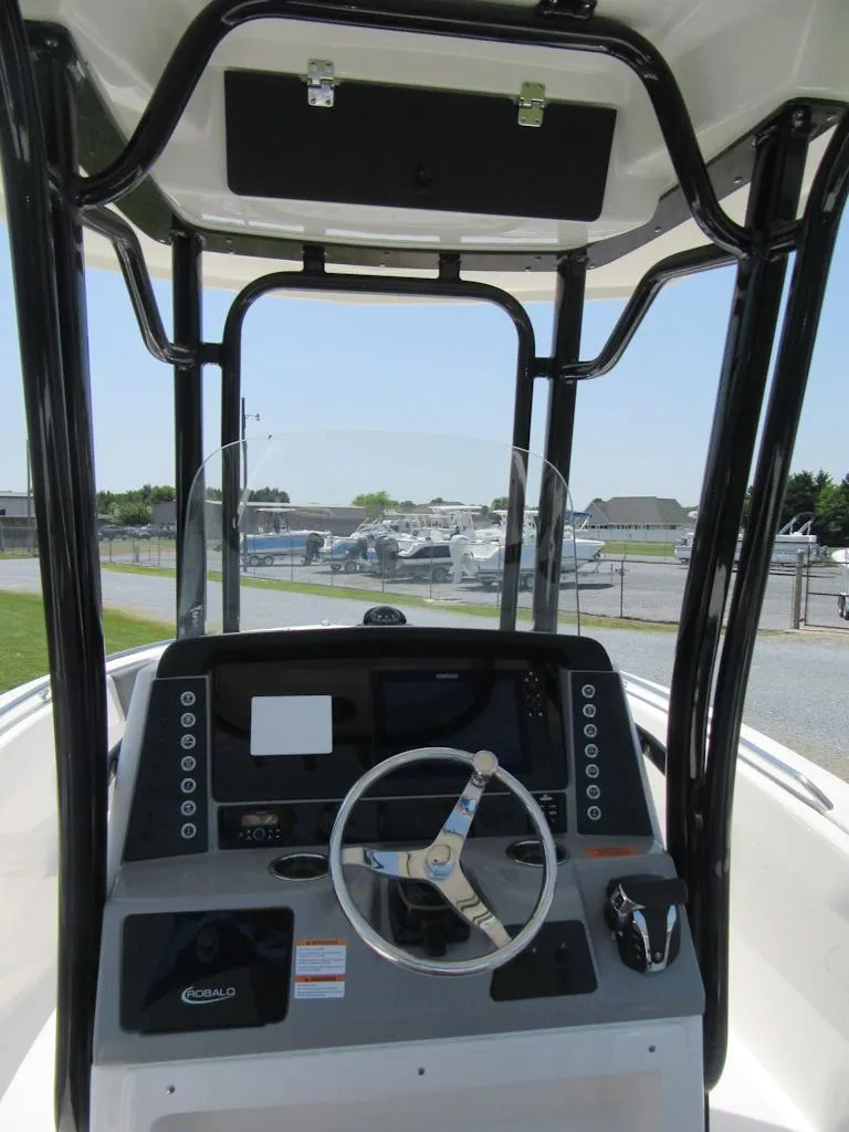 Slide: The Image of 2023 Robalo R230 Center Console boat helm with steering wheel and control panel. - 12