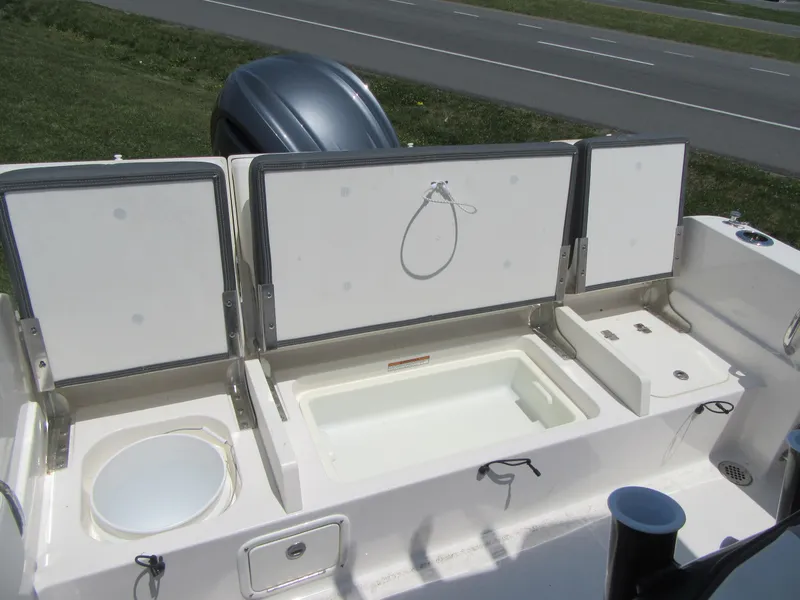 Slide: The Image of 2023 Robalo R230 Center Console boat storage compartments and livewell. - 17