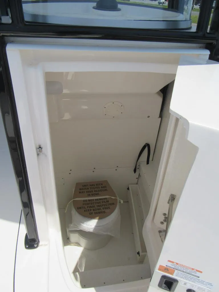 Slide: The Image of 2023 Robalo R230 Center Console boat interior compartment with toilet. - 9