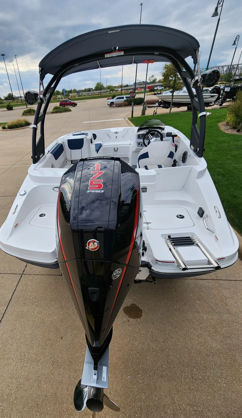 Slide: The Image of 2023 Tahoe 1950 boat with outboard motor, docked on a concrete surface. - 2