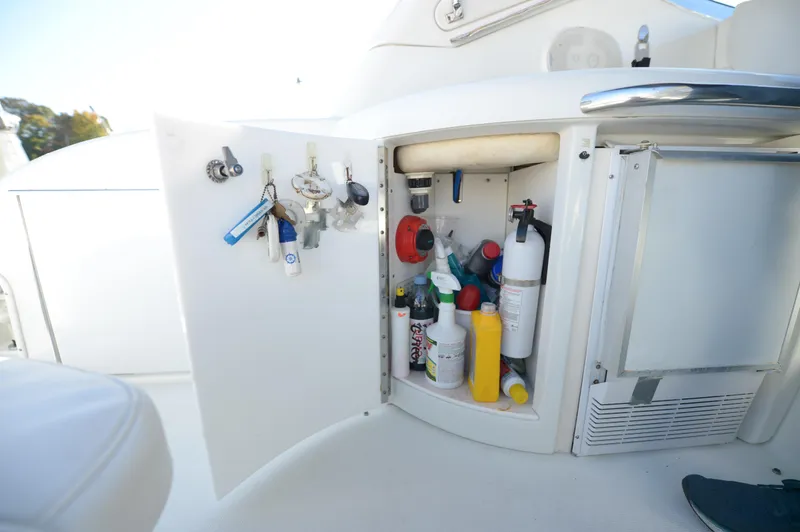Slide: The Image of Open storage cabinet on 2007 Formula 34 PC boat, containing cleaning supplies and keys. - 30