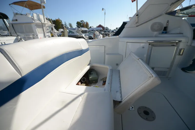 Slide: The Image of 2007 Formula 34 PC boat interior with white seating and storage compartment open. - 37