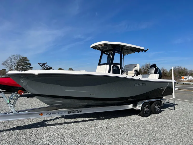 The Image of 2023 Blue Wave 2600 Makaira boat on a trailer under a clear blue sky. - 0