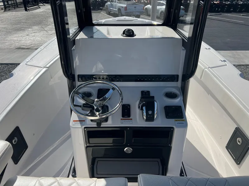 Slide: The Image of 2023 Blue Wave 2600 Makaira boat console with steering wheel and controls. - 11