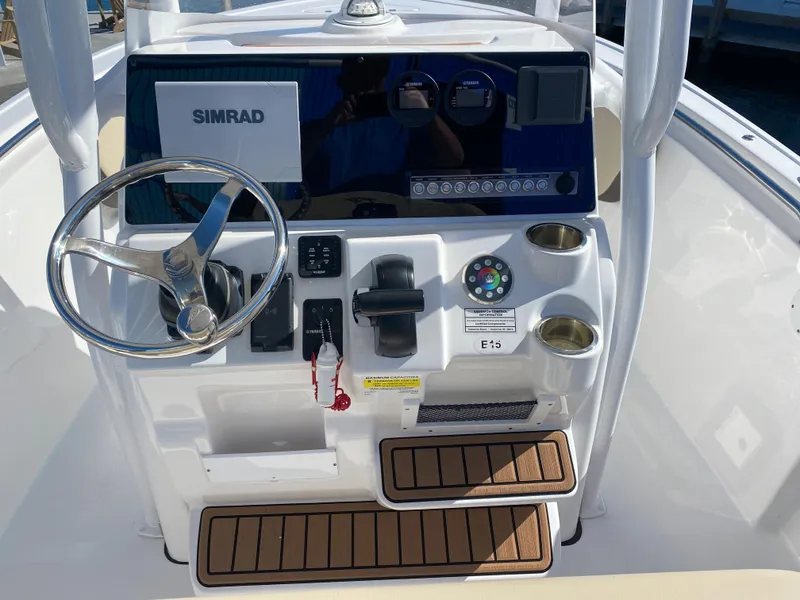 Slide: The Image of 2021 Tidewater 210 LXF boat console with Simrad electronics and teak steps. - 14