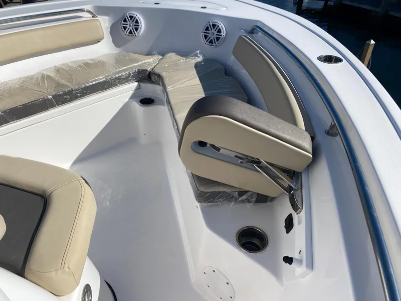 Slide: The Image of 2021 Tidewater 210 LXF boat interior with cushioned seating and speakers. - 25