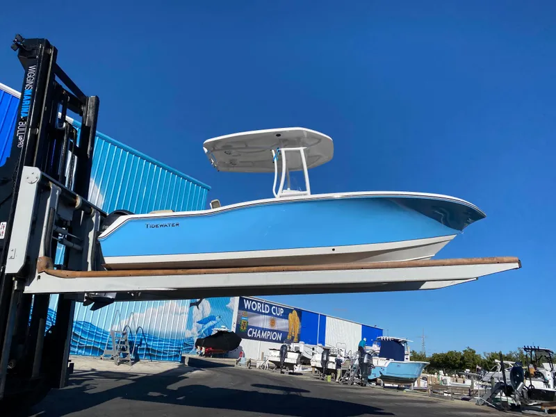 Slide: The Image of 2021 Tidewater 210 LXF boat on forklift at marina, blue hull, clear sky. - 3