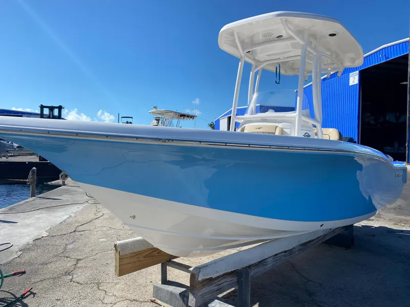 Slide: The Image of 2021 Tidewater 210 LXF boat in blue and white, docked at a marina. - 5
