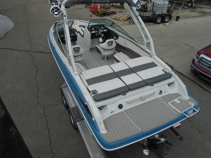 Slide: The Image of 2022 Crownline 240 SS boat on trailer, blue and white exterior, spacious seating. - 6
