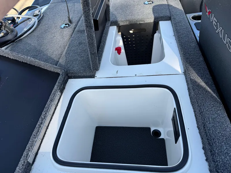 Slide: The Image of 2023 Vexus AVX181 boat storage compartments with gray carpeted interior. - 15