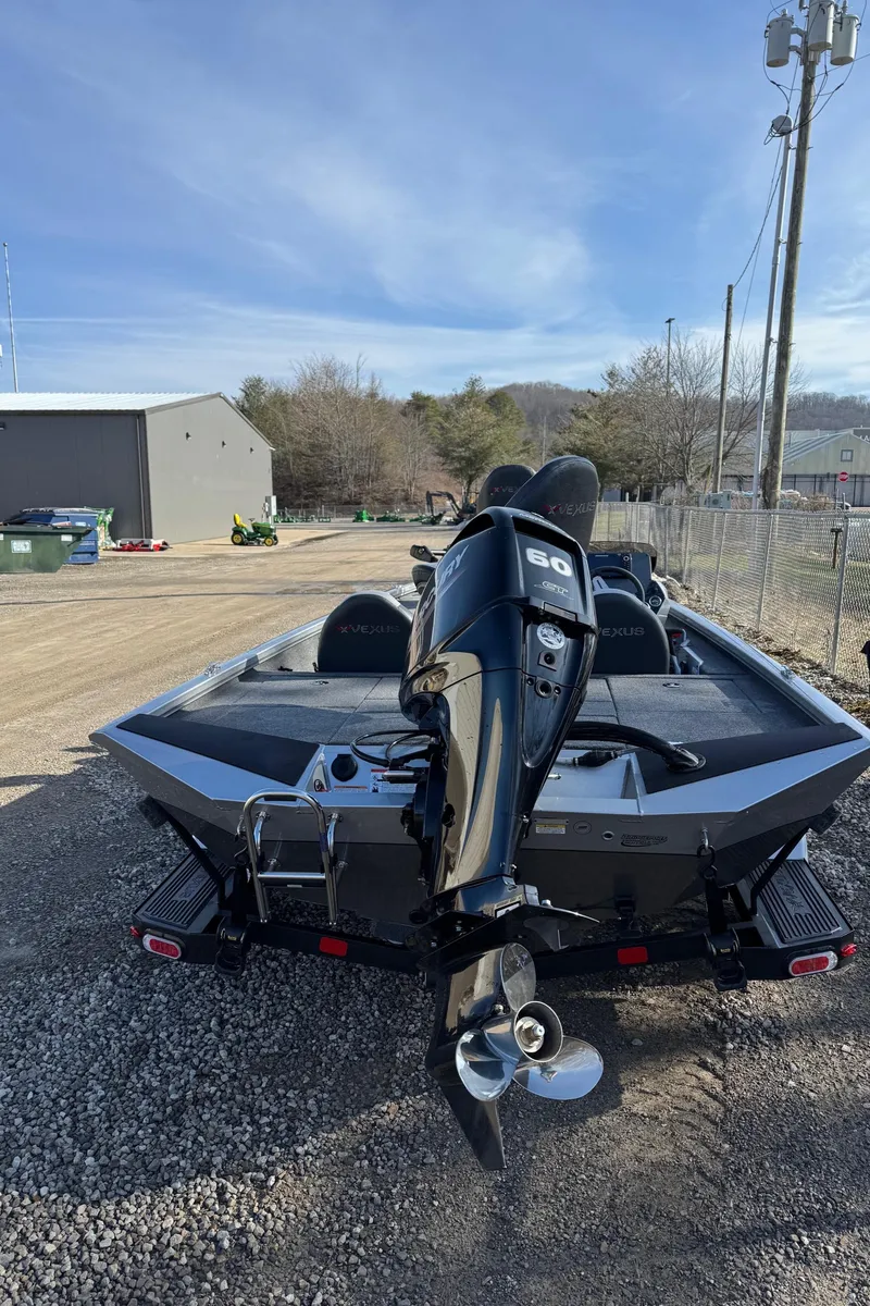 Slide: The Image of 2023 Vexus AVX181 boat with outboard motor, parked on gravel near a building. - 4