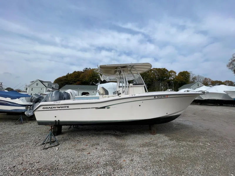 Slide: The Image of 2010 Grady-White 257 Advance boat on dry land, overcast sky background. - 0