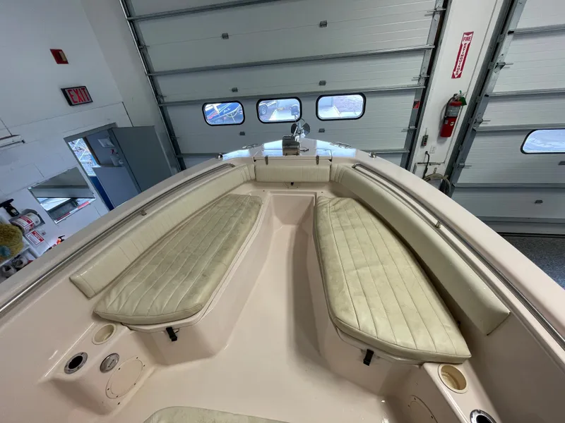 Slide: The Image of 2010 Grady-White 257 Advance boat interior with cushioned seating in a garage. - 16
