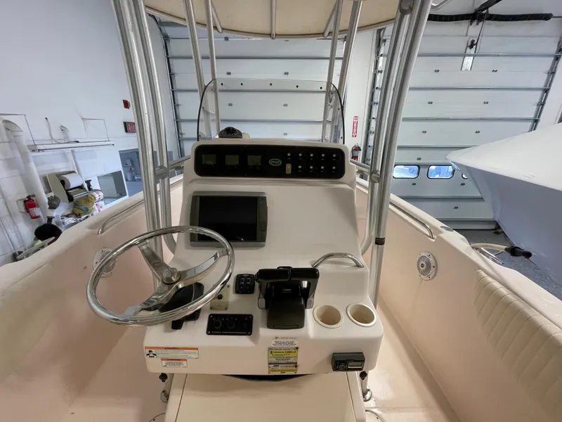 Slide: The Image of 2010 Grady-White 257 Advance boat console with steering wheel and controls in a garage. - 19